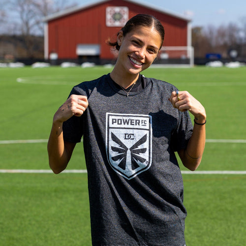 Person wearing a sports jersey with a logo on a soccer field